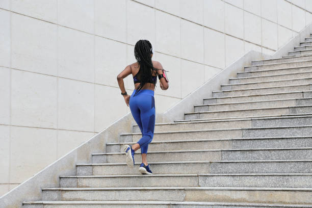 sportswoman running up the stairs - determination running staircase jogging imagens e fotografias de stock