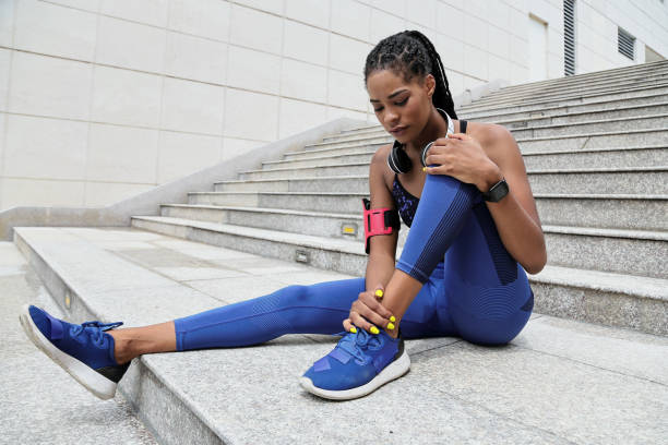 Suffering from pain in ankle Fit young Black sportswoman suffering from pain in her ankle after morning jog ankle stock pictures, royalty-free photos & images