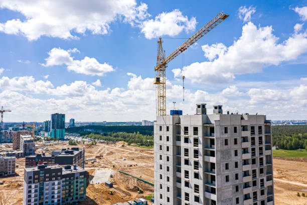 istock building crane and buildings under construction against blue cloudy sky. aerial view from flying drone 1279738239