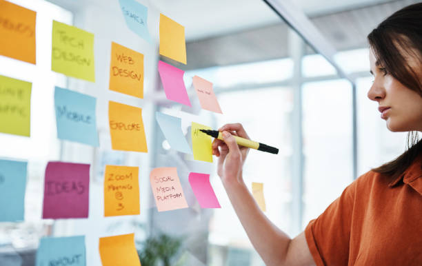 Success is so much closer when you visualise it Shot of a young businesswoman having a brainstorming session in a modern office paper stock stock pictures, royalty-free photos & images