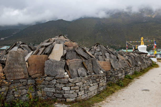 mani piedras en la aldea de khumjung el pueblo verde de la comunidad sherpa en la región de khumbu de nepal. - tibet tibetan culture buddhism writing fotografías e imágenes de stock