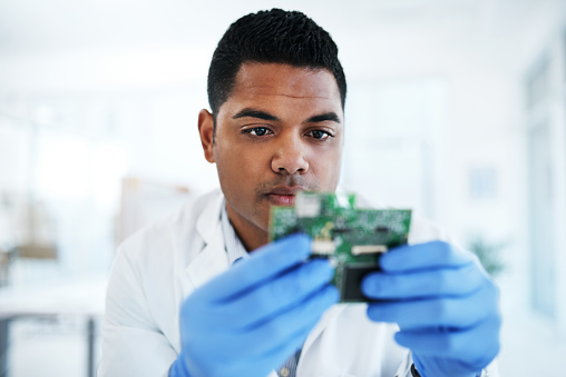 Shot of a young man repairing computer hardware in a laboratory