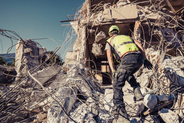 soccorritore ricerca attraverso rovine di edificio - terremoto foto e immagini stock