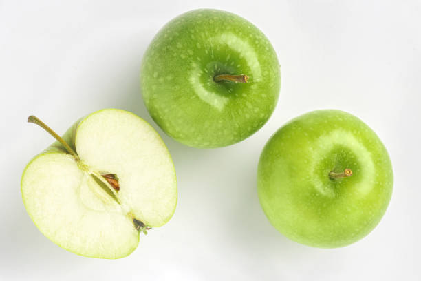 Half of ripe green apples on white background Top view Half of ripe green apples on a white background. Top view green apple slice overhead stock pictures, royalty-free photos & images