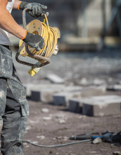 istock Builder using an extension lead for power plant and machinery on a building site. 1279743216