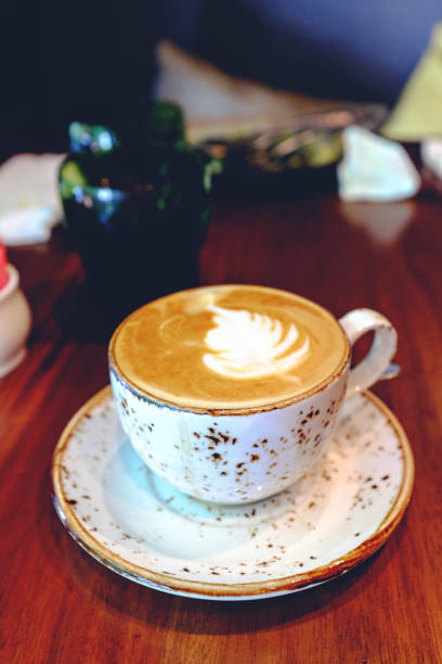 vertical shot of flat white coffee in a mug in a cafe