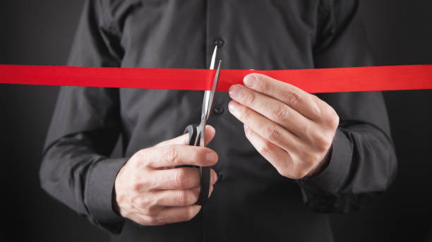 istock Man cutting red ribbon with a scissors. 1279745264
