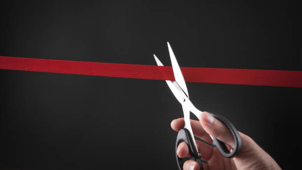 istock Male hand cutting red ribbon with a scissors. 1279745267