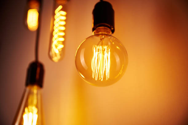 istock Set of a vintage light bulb on orange background, soft focus. Glowing edison bulb 1279746956