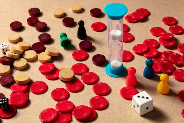istock Game night concept, an hourglass with pawns and dice 1279750715