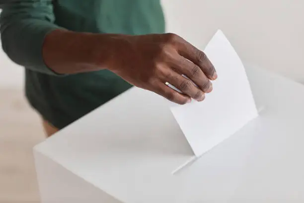 Close-up of African man holding ballot and giving his voice during voting