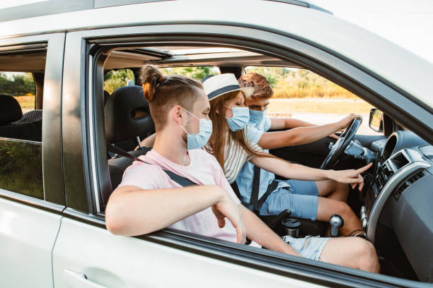 group of people riding in car with medical mask group of people riding in car with medical mask. coronavirus car rental covid stock pictures, royalty-free photos & images