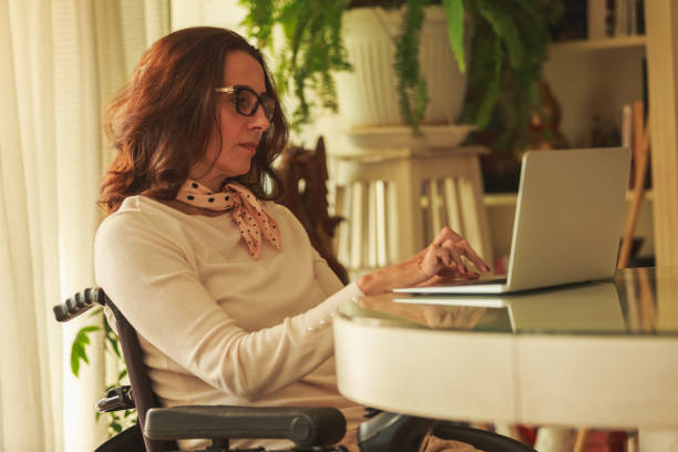 istock Woman in wheelchair using a laptop computer 1279760405