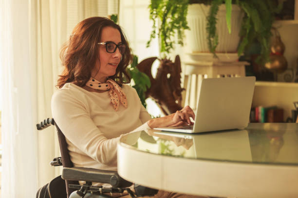 istock Woman using a laptop computer in front of table 1279760416