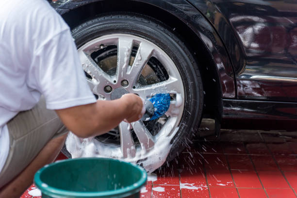 istock Man cleaning the car wheels 1279760589