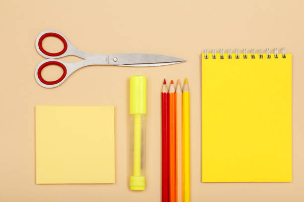 istock Note paper, scissors, felt pen, color pencils and notebook on beige background 1279761157