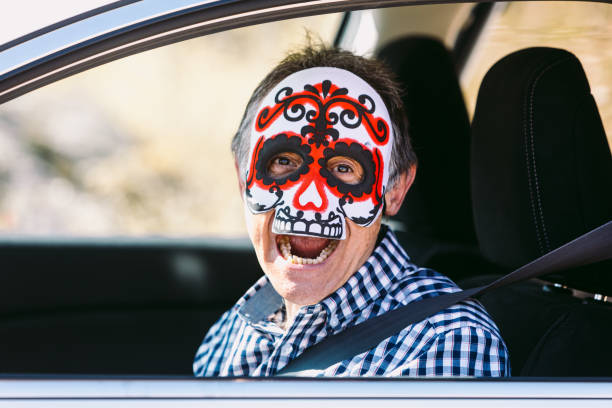 istock Man inside a car with a Hallowwen skull mask scaring 1279761964