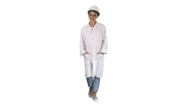 istock Woman in a white lab coat and hard hat walking on white backgrou 1279762154