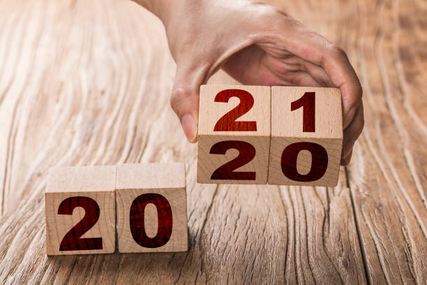 istock Hand flips a block changing 2020 to 2021. New year beginning. Holidays and Christmas. 1279762191