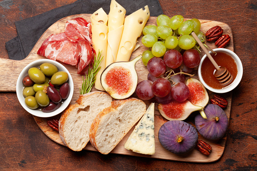 Antipasto plate with prosciutto, cheese, figs and grapes. Appetizer board. Top view flat lay