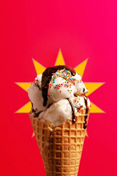 Waffle cone with ice cream, sprinkles and chocolate topping, food background.