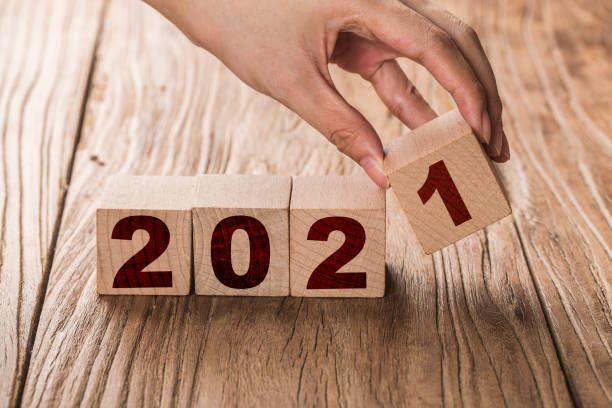 istock Hand flips a block changing 2020 to 2021. New year beginning. Holidays and Christmas. 1279762421