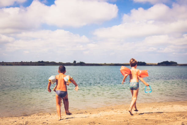 istock Small boys running at the beach on summer day. 1279762601