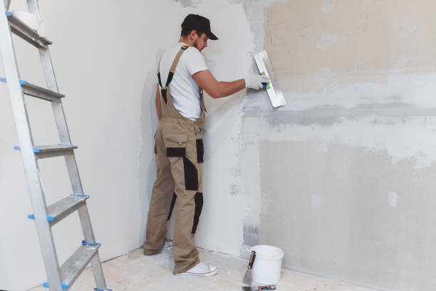 istock Male painter with a putty knife in his hands makes repairs in th 1279765109
