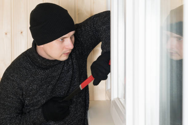 istock side view of a man in dark clothes breaking a plastic window with a tool 1279767867