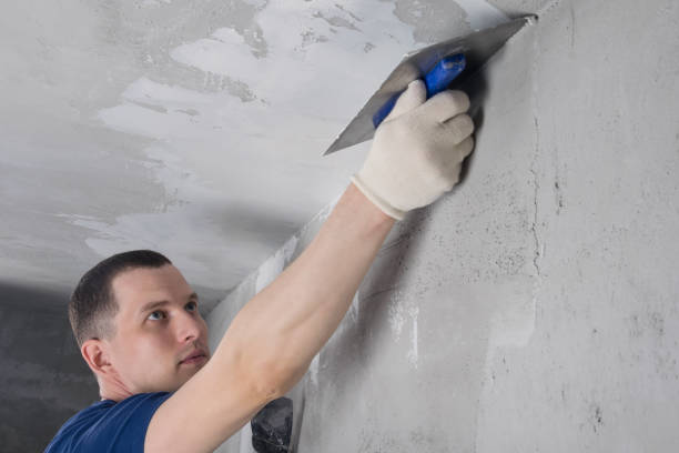 istock a man in blue special clothes repairs a concrete ceiling, bottom view 1279768086