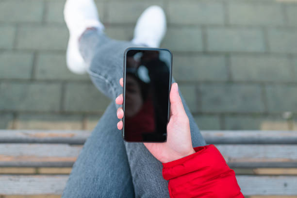 istock Woman sits on a bench and uses smartphone 1279769668