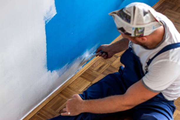 istock House painter beginning to paint a large blue wall. 1279771186