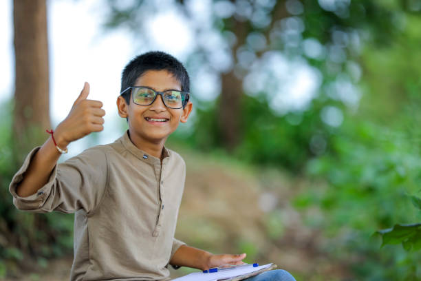 indian child wearing spectacles and showing thumbs up - facial expression child asia asian and indian ethnicities imagens e fotografias de stock