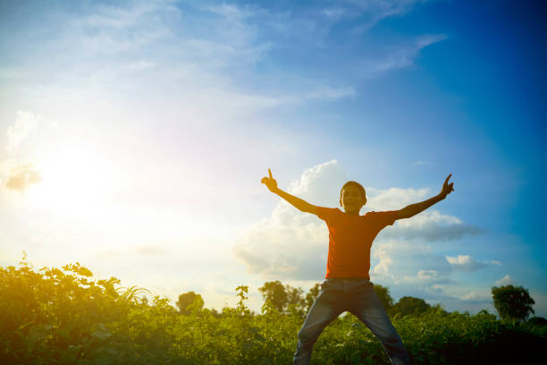 Handsome man is standing in the mountains with his arms wide open. Concept: back to nature, simple life