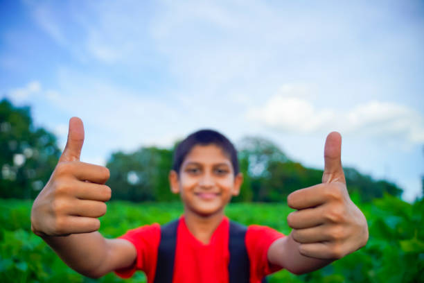 little Indian / Asian boy showing thumbs up , selective focus on hand