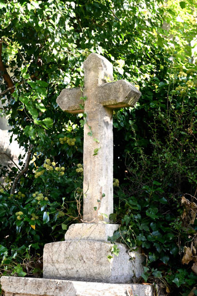 istock stone christian cross with greenery in the background 1279775517