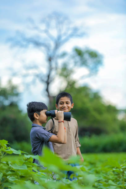 буксировка маленький индийский мальчик пользуется в природе с биноклем - little boys discovery binoculars child стоковые фото и изображения