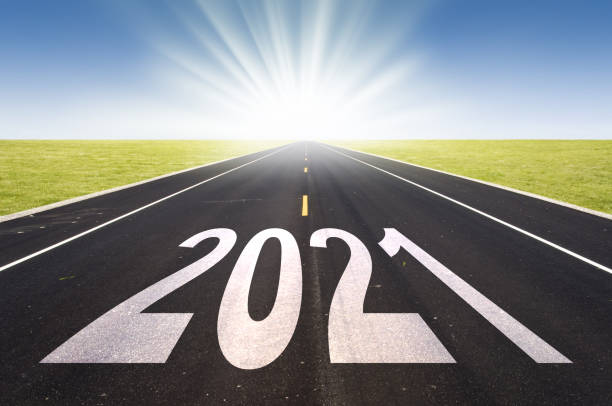 istock 2021 road perspective with rising sun, new year card 1279776620