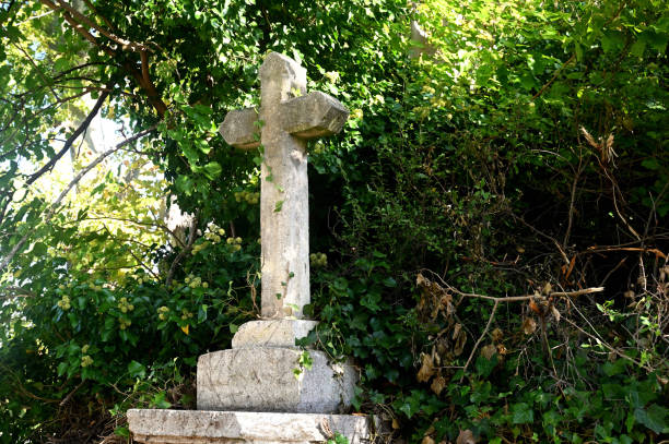 istock stone christian cross with greenery in the background 1279776626