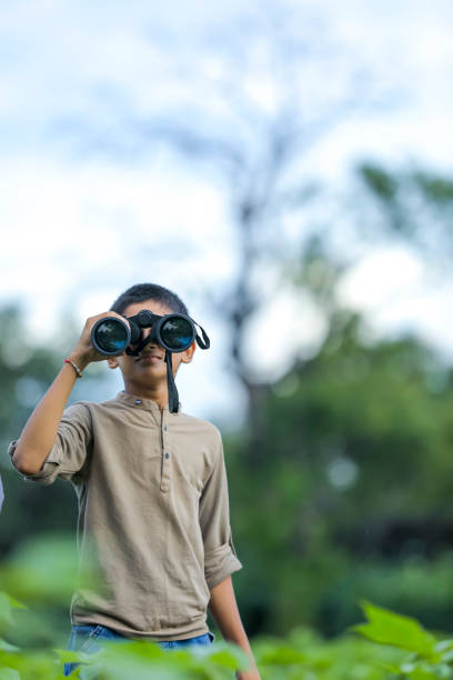 маленький индийский мальчик пользуется в природе с биноклем - little boys discovery binoculars child стоковые фото и изображения