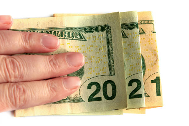 istock 2021 written with dollars bank notes in a hand isolated on white background, new year greetings money concept 1279777128