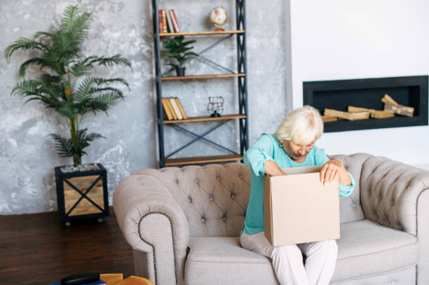 istock Senior woman is unpacking a cardboard box 1279778013