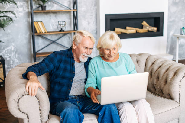istock Senior couple with a laptop indoors 1279778014