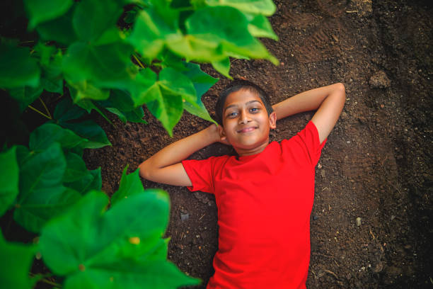 Smiling cute indian boy laying on ground