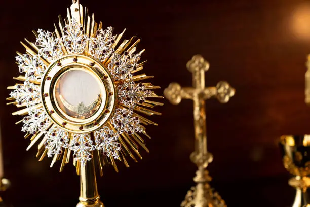 Catholic symbols composition: The Cross, monstrance and golden chalice.