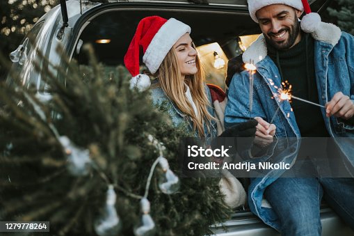 istock Couple having fun on Christmas tree adventure. 1279778264