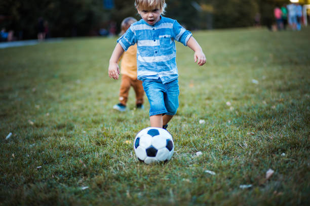 istock Little boy playing football. 1279781863