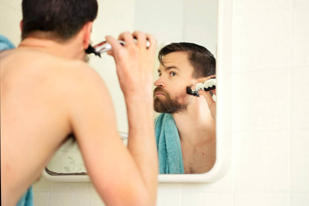 istock Man giving his beard a trim in a bathroom mirror 1279782956