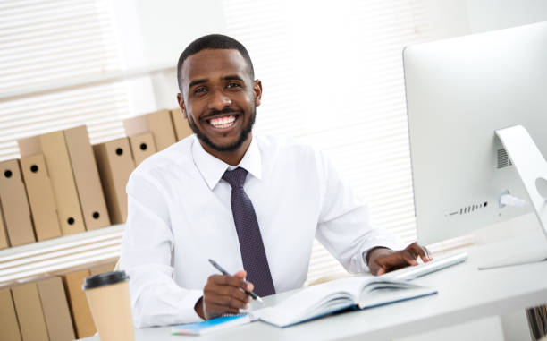 istock Happy handsome african american businessman smiling while looking at camera in office 1279784059