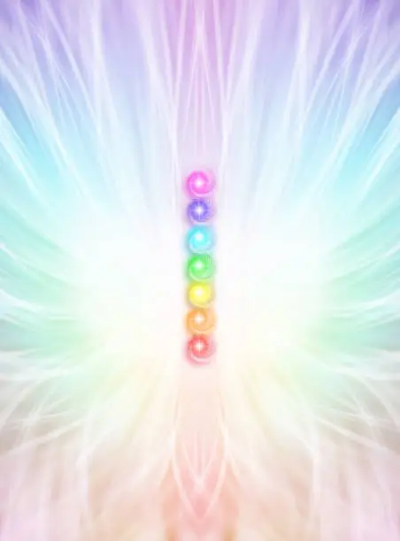 column of  seven chakras on a beautiful outward radiating rainbow coloured energy formation background with copy space